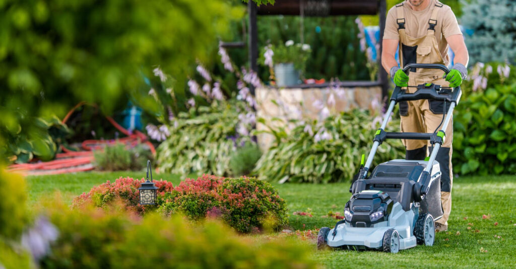 gardener-worker-trimming-grass-using-electric-mower